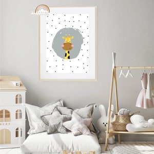 May include: A framed art print featuring a cartoon giraffe with a yellow body, brown muzzle, and black spots. The giraffe is set against a gray circle with a background of black polka dots. The print is in a light wood frame.