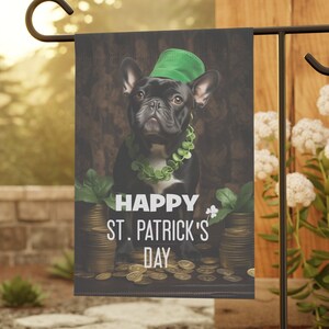 May include: A black French bulldog wearing a green hat and a green garland sits in front of a pile of gold coins. The text "Happy St. Patrick's Day" is written below the dog.
