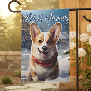 May include: A garden flag with a winter scene featuring a corgi dog wearing a red scarf. The flag has the text "Let it Snow" in white lettering.