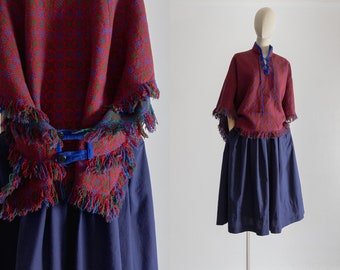 1960s Morfydd cape wool tapestry poncho mod coat, lace up v neck, stand collar, buttoned back, fringed hem, beet red, electric blue, green