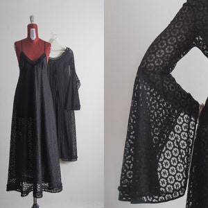 May include: Two black lace dresses, one with long bell sleeves and the other with spaghetti straps. Both dresses have a delicate floral pattern.