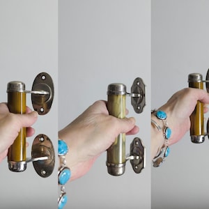 May include: A set of three vintage door handles with a chrome finish and a yellow-brown Bakelite centre. The handles are designed to be mounted on a door.