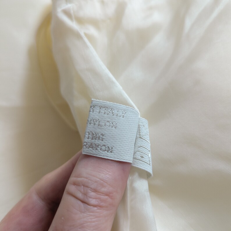 May include: White fabric label with the text "ITALY NYLON 100% RAYON" printed on it.