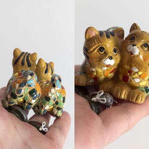 May include: A ceramic cat figurine with a pair of cats and two turtles. The cats are tan with black stripes and the turtles are decorated with colorful mosaic-like patterns. A small silver mouse figurine is also present.