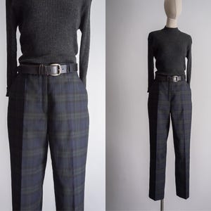 May include: A pair of black and green plaid pants with a brown leather belt. The pants have a straight leg and a mid-rise waist.