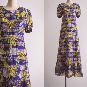 May include: A purple maxi dress with a yellow and green floral print. The dress has a ruffled hem and short puff sleeves.