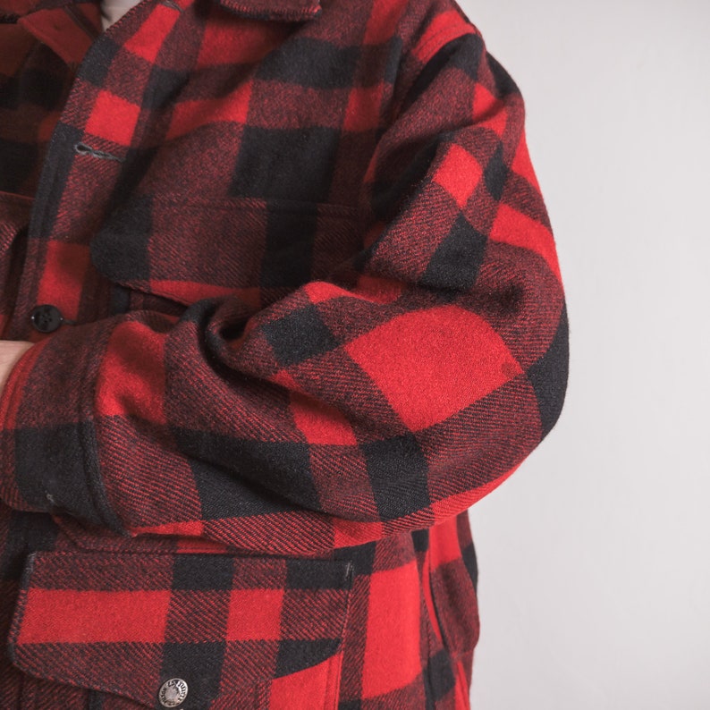 May include: Red and black checked flannel shirt with a button-up front and a patch pocket on the left side.