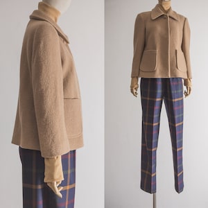 May include: A brown wool jacket with a collar and pockets. The jacket is worn over a plaid shirt and pants.