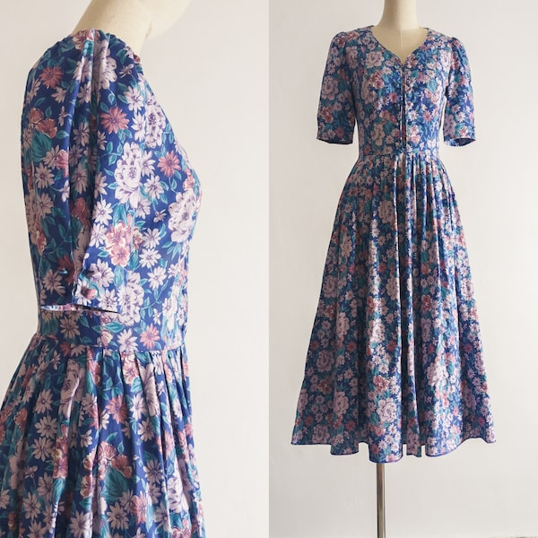 1980s Laura Ashley dress in rich muted floral chic pastel lilac dark brownish pink flowers teal leaves pattern on a french blue background