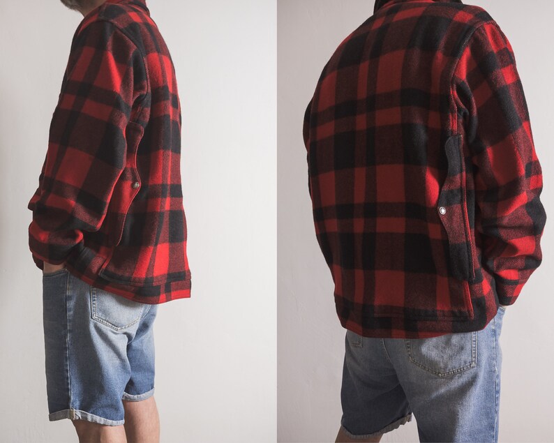 May include: A red and black checked flannel shirt jacket with a patch pocket on the left side. The jacket is worn over a pair of blue denim shorts.