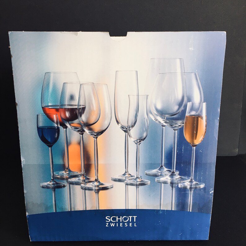 May include: A box of Schott Zwiesel glassware featuring a variety of wine glasses, including a red wine glass, a white wine glass, a champagne flute, and a sherry glass.
