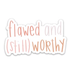 May include: Pink and white sticker with the text "flawed and (still) worthy".