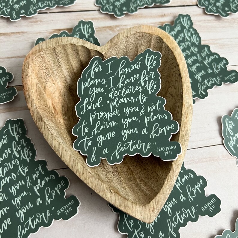 May include: Green and white sticker with the text "For I know the plans I have for you," declares the Lord. "Plans to prosper you and not to harm you, plans to give you a hope and a future." Jeremiah 29:11