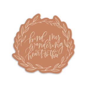 May include: A brown circle sticker with a white floral wreath and the text "bind my wandering heart to thee" in white cursive lettering.