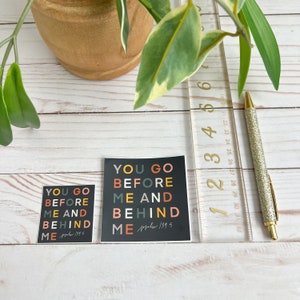 May include: Two black and white stickers with colourful text that reads "You go before me and behind me" with the bible verse "Psalm 139:5" on the bottom.