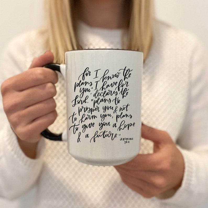 May include: White ceramic mug with a black handle. The mug has black lettering that reads "for I know the plans I have for you," declares the Lord, "plans to prosper you & not to harm you, plans to give you a hope & a future." Jeremiah 29:11