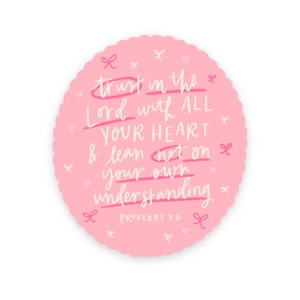 May include: A pink, scalloped-edge sticker with the handwritten text "trust in the Lord with ALL YOUR HEART & lean not on your own understanding" and "PROVERBS 3:6". The design includes small bows and hearts.