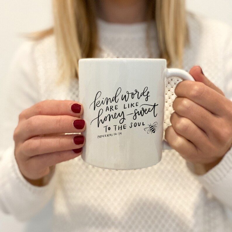 May include: White ceramic mug with black lettering that reads "Kind words are like honey-sweet to the soul, Proverbs 16:24". A small bee illustration is next to the text.