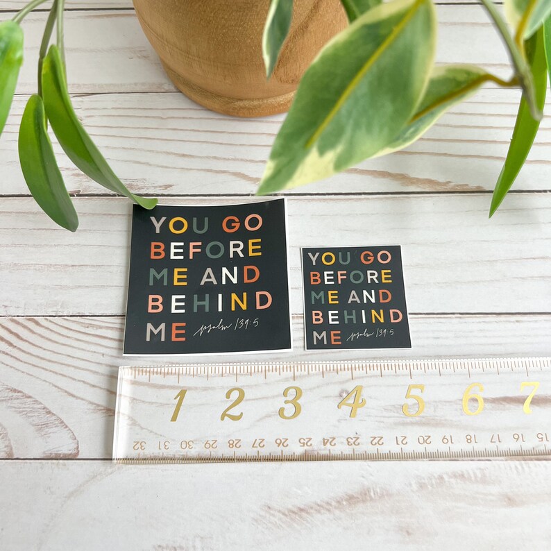 May include: Two black square stickers with the text "You go before me and behind me" in colourful letters. The text is from Psalm 139:5.