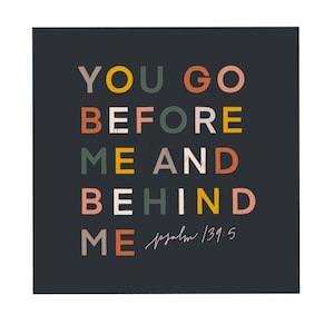 May include: A black background with colourful text that reads "You go before me and behind me" with the scripture reference "Psalm 139:5" in smaller text below.