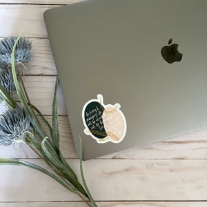 May include: A black and pink heart-shaped sticker with gold accents. The sticker features a quote from the Bible, "Be strong and courageous. Do not be afraid; do not be discouraged, for the Lord your God will be with you wherever you go." - Joshua 1:9