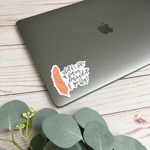 Op de afbeelding: Een sticker met een verenpatroon en de tekst "what if I fell? oh but my darling what if you fly?"