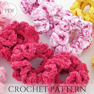 May include: Crochet pattern PDF for making colorful hair scrunchies. The scrunchies are made with a soft, fuzzy yarn in pink, white, and yellow.