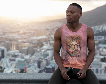 May include: A man wearing a pink tank top with a colorful abstract face print sits on a ledge overlooking a city. He is holding a black water bottle.