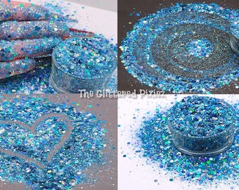 Puede incluir: Primer plano de un tarro de purpurina azul e iridiscente. La purpurina está esparcida alrededor del tarro, creando un efecto brillante. La purpurina es perfecta para añadir un toque de brillo a las manualidades, el arte de las uñas y mucho más.