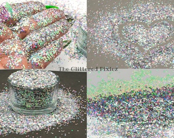 May include: A close-up of iridescent silver glitter with a variety of sizes and shapes. The glitter is shown in a jar, in a pile, and in a hand.