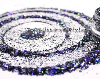 May include: A small jar of black and iridescent glitter with a purple and green shimmer. The glitter is scattered around the jar in a circular pattern.