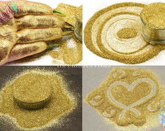 May include: A close-up of a jar of fine gold glitter. The glitter is shown in a pile, on a hand, and in a heart shape. The glitter is very fine and has a metallic sheen.