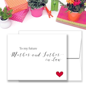 May include: A white card with a red heart and the text "To my future Mother and Father in-law" in black calligraphy.
