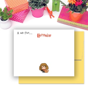 May include: A white card with a yellow envelope. The card has a note that says "A note from... Hermione" with a cartoon image of Hermione Granger from Harry Potter with her cat, Crookshanks.