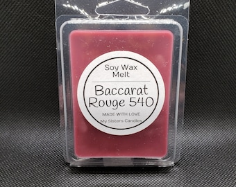Puede incluir: Un derretido de cera de soja rojo en un recipiente de plástico transparente. La etiqueta dice "Soy Wax Melt Baccarat Rouge 540 Made with Love My Sisters Candles".