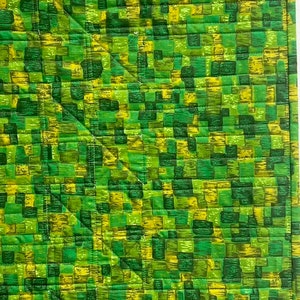 K&ouml;nnte beinhalten: Gr&uuml;ner und gelber gesteppter Stoff mit einem geometrischen Muster aus Quadraten und Rechtecken.