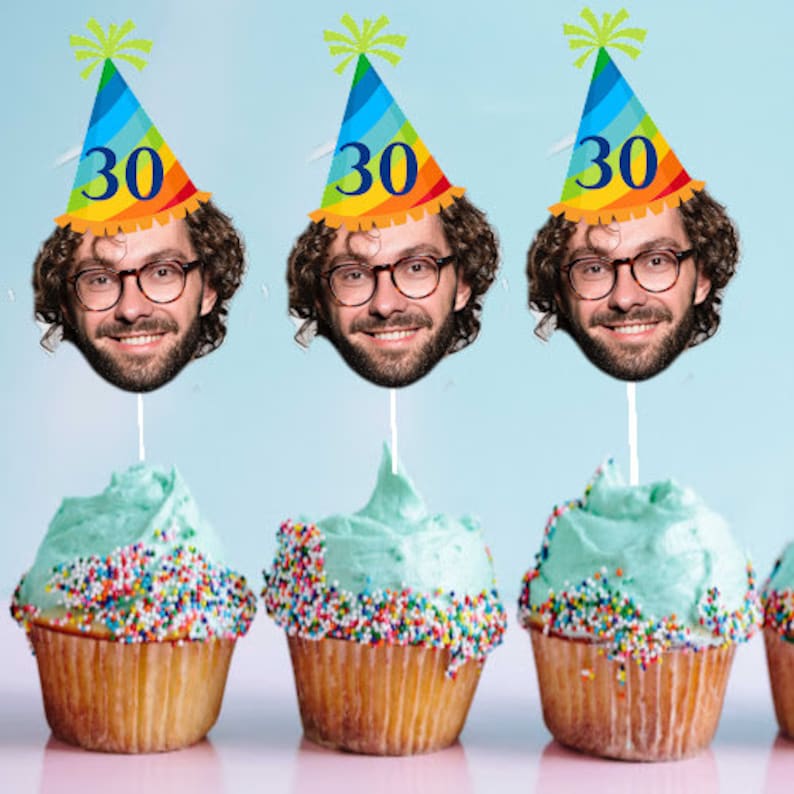 May include: Three cupcakes decorated with colorful sprinkles and topped with a birthday hat featuring a face cutout and the number "30".