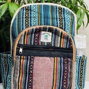 Può includere: Uno zaino in canapa a strisce blu e marroni con una tasca nera e una toppa che dice "Himalayan Hemp The Free Nepal Hemp".