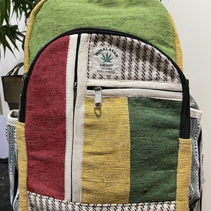 May include: A green, red, yellow and white striped hemp backpack with a black zipper and a patch that says "Himalayan Hemp THC Free Made in Nepal".