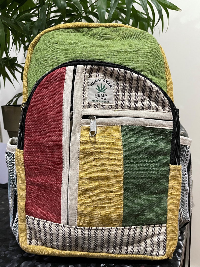 May include: A green, red, yellow and white striped hemp backpack with a black zipper and a patch that says "Himalayan Hemp THC Free Made in Nepal".