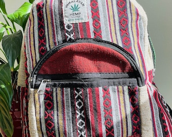 May include: A red, black, white and yellow striped hemp backpack with a brown leather patch that says "Himalayan Hemp THC Free Made in Nepal".