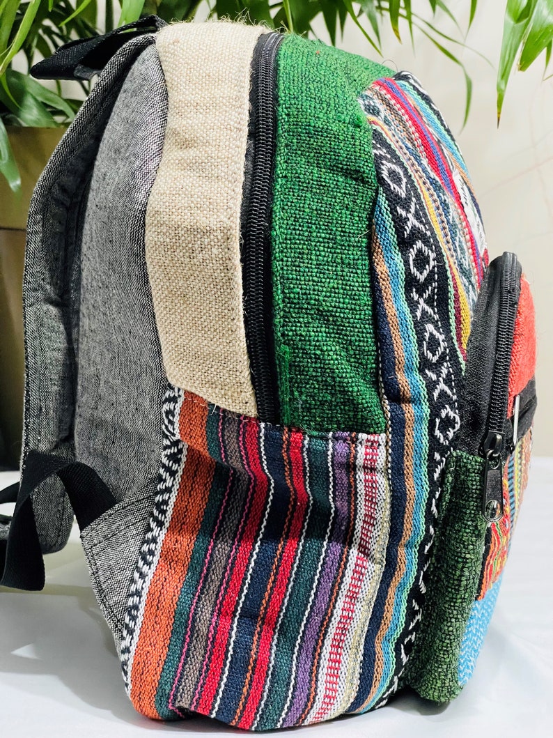 May include: A multi-colored striped and solid fabric backpack with a zippered pocket. The backpack is made of a variety of fabrics, including green, blue, red, and black.