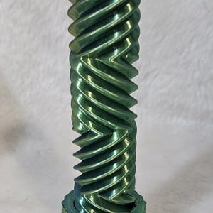 Op de afbeelding: Een groen 3D-geprint tandwiel met een spiraalvormig ontwerp. Het tandwiel is gemaakt van plastic en heeft een gladde afwerking.