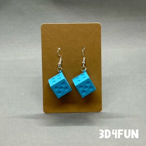 May include: A pair of blue dice-shaped earrings with silver hooks. The earrings are displayed on a brown card with the text "3D4FUN" printed below.