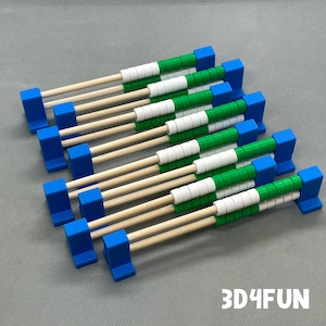 May include: A set of nine wooden abacus frames with green and white beads. The frames are blue and have a wooden dowel rod. The abacus frames are arranged in a staggered pattern. 3D4FUN is printed on the surface below the abacus frames.
