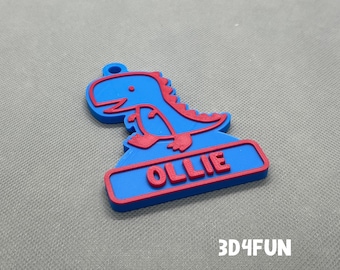 Op de afbeelding: Blauw en rood 3D-geprint dinosaurus sleutelhanger met de naam "Ollie" op de basis.
