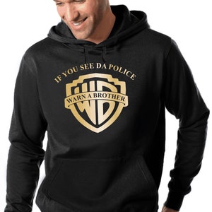 Könnte beinhalten: Schwarzer Kapuzenpullover mit einem goldenen Grafik eines Schildes mit dem Text "If you see da police warn a brother" im Inneren.