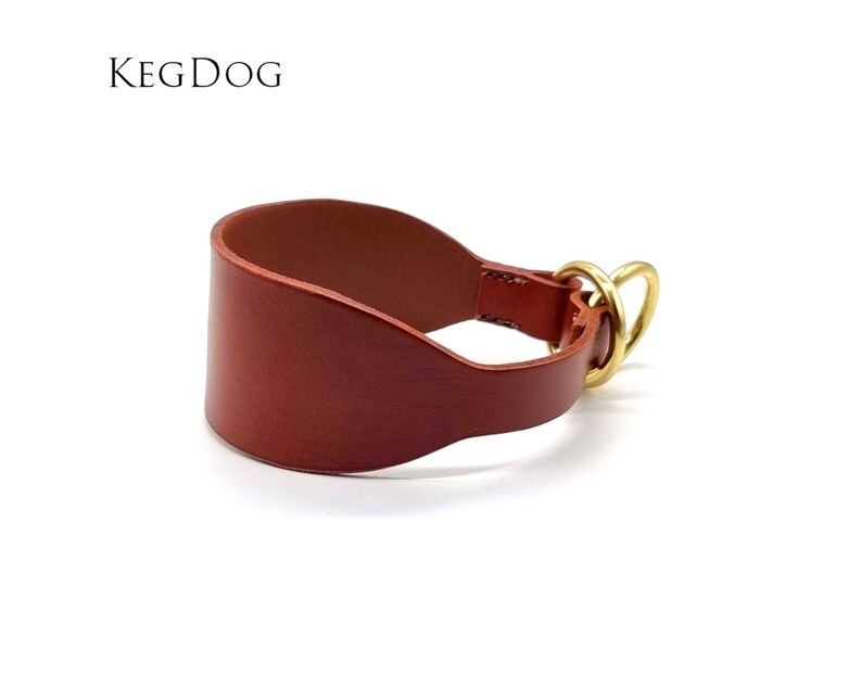 May include: A brown leather dog collar with a brass buckle and D-ring. The collar is designed to fit snugly around the dog's neck and is made of high-quality leather.