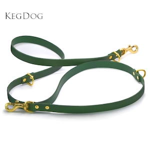 May include: A green leather dog leash with two gold metal clips. The leash is designed to be used with two dogs.