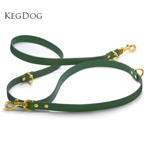 May include: A green leather dog leash with two gold metal clips. The leash is designed to be used with two dogs.